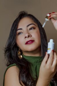 Portrait of a woman using skincare serum with a dropper for facial care.